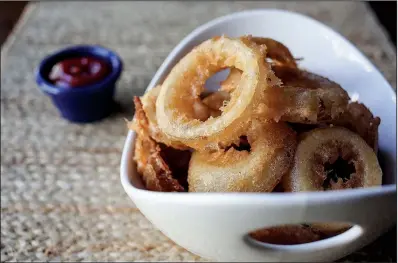  ?? Food styling/KELLY BRANT Arkansas Democrat-Gazette/MITCHELL PE MASILUN ?? Beer-Battered Onion Rings are shattering­ly crisp and flavorful thanks to brown ale and a medley of spices.