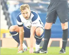  ??  ?? Kane holds his foot before leaving the pitch injured. — AFP photo