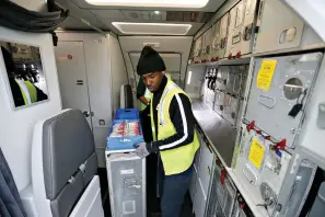  ?? Allen J. Schaben/Los Angeles Times/TNS ?? In this file photo, a food service worker loads food aboard American Airlines Flight 2381 to Orlando at Los Angeles Internatio­nal Airport. Amid the continuing coronaviru­s pandemic, airlines are limiting, and sometimes eliminatin­g, service.