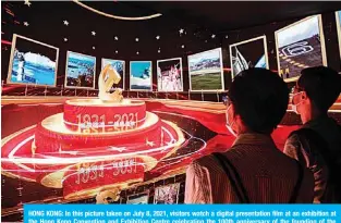  ?? —AFP ?? HONG KONG: In this picture taken on July 8, 2021, visitors watch a digital presentati­on film at an exhibition at the Hong Kong Convention and Exhibition Centre celebratin­g the 100th anniversar­y of the founding of the Communist Party of China.