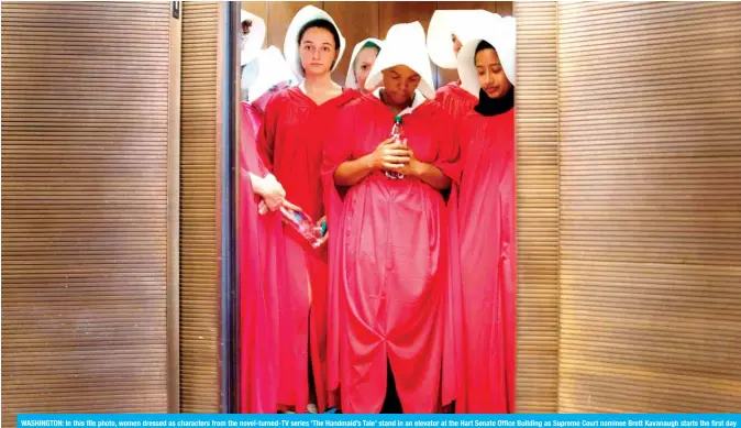  ?? — AFP ?? WASHINGTON: In this file photo, women dressed as characters from the novel-turned-TV series ‘The Handmaid’s Tale’ stand in an elevator at the Hart Senate Office Building as Supreme Court nominee Brett Kavanaugh starts the first day of his confirmati­on hearing in front of the US Senate on Capitol Hill. From US to Argentina, the red habit and white bonnet synonymous with ‘The Handmaid’s Tale’ have become a powerful symbol of the #MeToo movement.