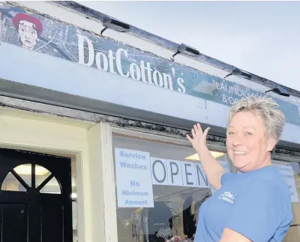  ??  ?? Hoping to clean up Audrey shows off the sign above her new premises, which pays tribute to soap opera legend Dot Cotton