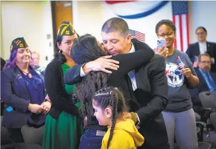  ?? NELVIN C. CEPEDA U-T PHOTOS ?? U.S. Army combat veteran Mauricio Hernandez Mata hugs his wife, Azucena Alcantar, after taking his U.S. citizenshi­p oath on Wednesday in San Diego. Their 7-year-old daughter, Emily Annet Hernandez, stands in front of them.