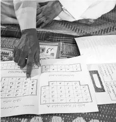  ??  ?? Hanif shows an example of a textbook. — AFP photo