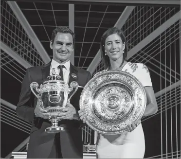  ?? THOMAS LOVELOCK/AELTC, POOL VIA AP ?? Wimbledon singles champions Roger Federer of Switzerlan­d and Garbine Muguruza of Spain pose with their trophies at the Champions Dinner on Sunday night at The Guildhall in London.