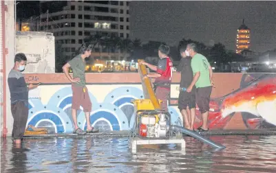  ?? NUTTHAWAT WICHEANBUT ?? Return to sender
Locals in Samphantha­wong district of Bangkok use a water pump alongside the Chao Phraya River to drain floodwater from a local shrine yesterday.