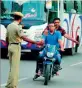  ??  ?? A cop stops a motorcycli­st for checks.