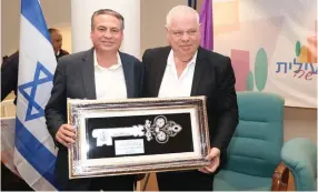  ?? (Iki Maimon) ?? UZI DAYAN (left) receives the key to the city of Upper Nazareth from Mayor Ronen Plot.