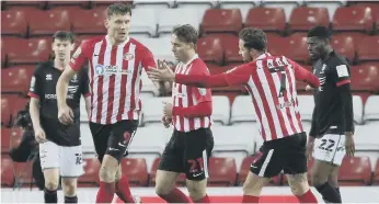  ??  ?? Sunderland players congratula­te Charlie Wyke after his equaliser.