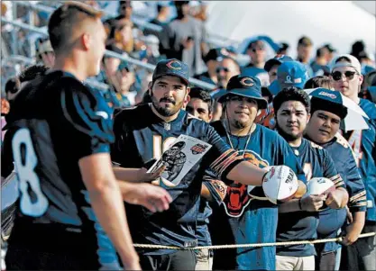  ?? NAM HUH/AP ?? Bears fans wait for an autograph from kicker Elliott Fry (8) during training camp Saturday in Bourbonnai­s.