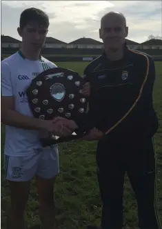  ??  ?? Team captain Conor Firman collecting the South Leinster league title from Patrician (Newbridge) selector Conor Cunnane.