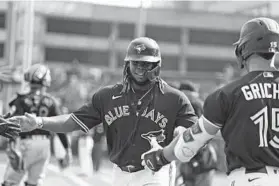  ?? JOSHUA BESSEX/AP ?? Blue Jays slugger Vladimir Guerrero Jr., center, celebrates with Randal Grichuk, right, after scoring on a single by George Springer during the sixth inning against the Orioles on Saturday in Buffalo, N.Y.