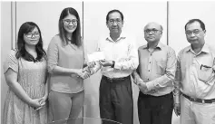  ??  ?? Tham hands over the donation cheque to Lim.