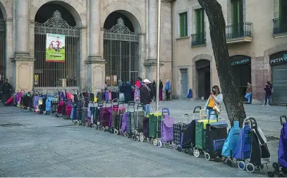  ?? AP ?? Decenas de carros en fila esperando para que sus dueños reciban comida en una iglesia de Barcelona