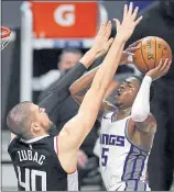  ?? MARK J. TERRILL — THE ASSOCIATED PRESS ?? Kings guard De’Aaron Fox, right, shoots past Clippers center Ivica Zubac during the second half Sunday.