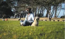  ?? Carlos Avila Gonzalez / The Chronicle ?? Marylee Cabrera wears a mask while out with her dog at the Emeryville Marina. More people are wearing masks outside.