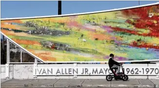  ?? PHOTOS BY BOB ANDRES / ROBERT.ANDRES@AJC.COM ?? A scooter rider travels across the colorful PATH Foundation pedestrian bridge, which was dedicated Monday to the memory of the legendary Atlanta mayor Ivan Allen Jr.