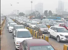  ?? YOGENDRA KUMAR/HT PHOTO ?? Long queues of vehicles at the Kherki-daula toll plaza on the second day since FASTAG toll was implemente­d, in Gurugram on Monday.