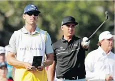  ?? THE ASSOCIATED PRESS ?? Rickie Fowler and his caddie, Joe Skovron, look over a shot before hitting from the 12th tee at The Players.