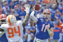  ?? AP PHOTO/JOHN RAOUX ?? Florida quarterbac­k Kyle Trask unleashes a pass as Tennessee defensive lineman Matthew Butler puts a hand up during Saturday’s game in Gainesvill­e, Fla. Florida won 34-3 to improve to 4-0.