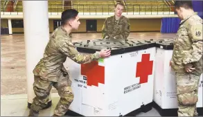  ?? Arnold Gold / Hearst Connecticu­t Media ?? Members of the Connecticu­t National Guard move boxes of supplies into place in Southern Connecticu­t State University's Moore Field House in New Haven in preparatio­n for a 250-bed field hospital on Tuesday.