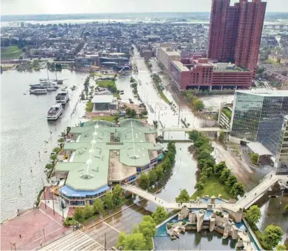  ?? AMY DAVIS/BALTIMORE SUN ?? The morning after Isabel hit, the Inner Harbor looked more like Venice, with Pratt and Light streets closed to vehicular traffic due to flooding. The Harborplac­e promenade, to the left of the Light Street Pavilion, was underwater.