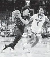  ?? JAYLYNN NASH USA TODAY Sports ?? University of Miami guard Nijel Pack drives on NC State guard Jayden Taylor on Tuesday night at PNC Arena in Raleigh. Pack had all of his points in the second half.