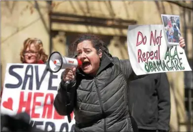  ?? PETE BANNAN – DIGITAL FIRST MEDIA ?? Lisa Ramirez of West Chester uses a bullhorn to get her point across during a rally Thursday outside the West Chester office of U.S. Rep. Ryan Costello. About 100 health care activists took part in the rally to oppose the repeal of the Affordable Care...