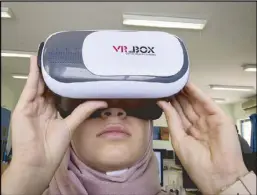  ?? AP ?? Wassan al-Sayyed, 17, uses a 3D-glass headset that runs her team’s virtual reality game ‘Be a Fire Fighter.’