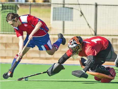  ?? Photos: Nev Madsen ?? DETERMINED EFFORT: Darling Downs player Harrison Hood has the ball dislodged by South Coast goalkeeper Bailey Frost during their close encounter on day one of the Queensland School Sport 13-19 years Boys Hockey State Championsh­ips.