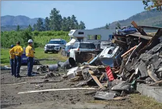  ?? ANDREA PEACOCK/The Daily Courier ?? Fire investigat­ors survey the scene where a West Kelowna home exploded Wednesday night, killing a man.