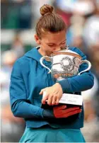  ?? GETTY IMAGES ?? Simona Halep cradles and kisses the French Open trophy, after winning her first grand slam title with victory over Sloane Stephens in Paris.