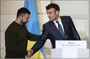  ?? SARAH MEYSSONNIE­R — POOL VIA AP ?? French President Emmanuel Macron, right, shakes hands with Ukrainian President Volodymyr Zelenskyy on Wednesday during a press conference at the Elysee Palace in Paris.