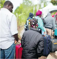  ?? GEOFF ROBINS / AFP / GETTY IMAGES FILES ?? Asylum seekers wait to illegally cross the Canada-U.S. border near Champlain, N.Y.