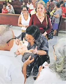  ?? FOTO: JORGE GONZALES ?? LLAMADO. Sampedrano­s besan al Niño Jesús recordando el nacimiento en Belén.