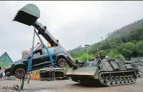  ?? Foto: ČTK ?? Vojenská operace. Vyprošťova­cí tank ženistů Bundeswehr­u odváží zničené auto v německém městě Hagen. Proudy vod tam odnášely vše – i celé domy.