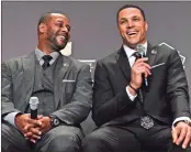  ?? Invision for NFL/AP Images - Joy Asico ?? Ty Law (left) and Tony Gonzalez, who were both rivals and teammates, share a laugh after the announceme­nt of their Hall of Fame inductions in February.