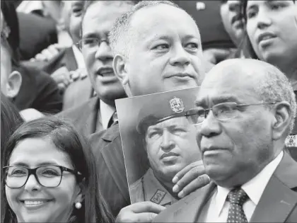  ??  ?? Los asambleíst­as Delcy Rodríguez, Diosdado Cabello (con la imagen del fallecido ex presidente Hugo Chávez) y Aristóbulo Istúriz, en la inauguraci­ón de los trabajos para reformar la Constituci­ón ■ Foto Ap