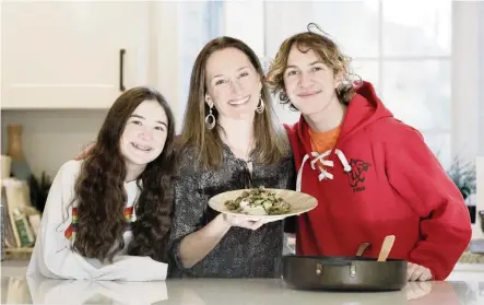  ?? ELIZABETH ROBERTSON Philadelph­ia Inquirer/TNS ?? Stephanie Zinn is among the coordinato­rs and contributo­rs to a cookbook called “Pots and Pandemic: Cooking in Quarantine.” She displays her ground beef and broccoli with Abigail Zinn, 13, left, and Cody Zinn, 16.