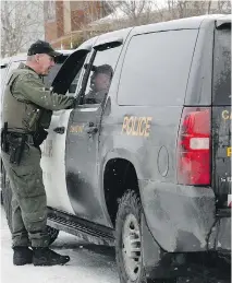  ?? MARIE-FRANCE COALLIER ?? An officer with the Ontario Provincial Police speaks to a colleague outside a house on Friday in Brossard, where a woman and her infant child have been missing since April of 2014.