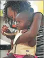  ?? ISAAC KASAMANI / AFP ?? Engineer Olivia Koburongo fits a child with the “MamaOpe” kit at the Makerere University of Public Health in Kampala.