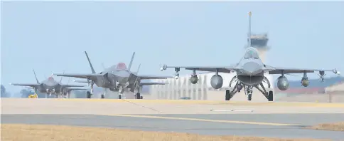  ?? — AFP photo ?? This handout photo provided by US Air Force shows US Air Force F-16 Fighting Falcon (right) and F-35A Lightning II fighter jets taxiing at Kunsan Air Base in the southweste­rn port city of Gunsan.