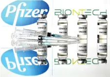  ?? — AFP photo ?? An illustrati­on picture shows vials with Covid-19 Vaccine stickers attached and syringes with the logo of US pharmaceut­ical company Pfizer and German partner BioNTech.