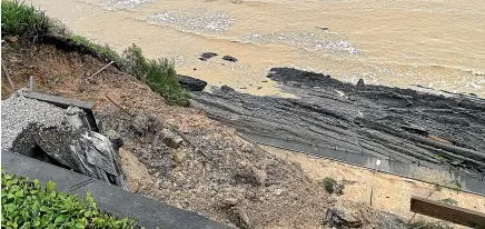  ?? WAKA KOTAHI NZ TRANSPORT AGENCY ?? Looking down from above a slip that fell on to the Rocks Rd section of State Highway 6 in Nelson, forcing its closure.
Paul McGuire and daughter Camille McGuire, 8, braved the downpour to get as close as they dared to the flooded Maitai River in Nelson.