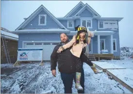  ??  ?? Chris Flett and his daughter, Jessica, stand outside their house this week that was rebuilt after being destroyed in a wildfire last year in Fort McMurray, Alta. After losing his house last May, Flett won the lottery in December.