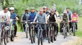  ?? MUHAIZAN YAHYA
PICBY ?? Tan Sri Mohamad Fuzi Harun (centre) taking part in a 5km cycling ride at a National Sports Day event in Bota, Perak, yesterday.