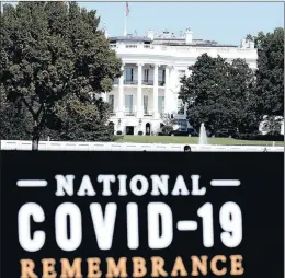  ?? JOSE LUIS MAGANA/AP ?? A sign for the COVID-19 Remembranc­e is seen Sunday near the White House. President Trump returned home Monday after a brief stay at a military medical hospital.