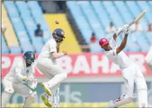  ??  ?? Indian cricketer Prithvi Shaw jumps in the air to take evasive action following a shot from West Indies batsman Roston Chase during the third day’s play of the first Test cricket match between India and West Indies at theSaurash­tra Cricket Associatio­n Stadium in Rajkot on Oct 6. (AFP)