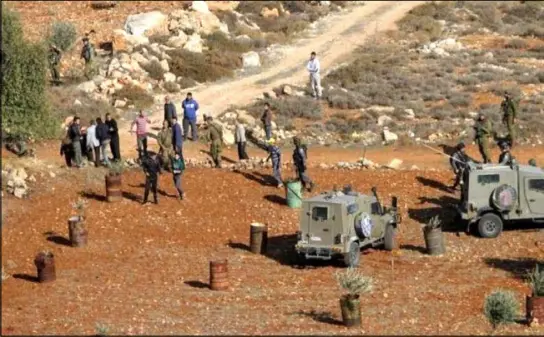  ??  ?? جيش الاحتلال يبعد فلسطينيين عن أرض أعلن عن مصادرتها في منطقة رام الله