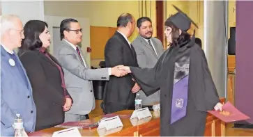  ?? ?? Una alumna egresada recibe su documentac­ión de manos del director de la facultad Javier Contreras Orozco